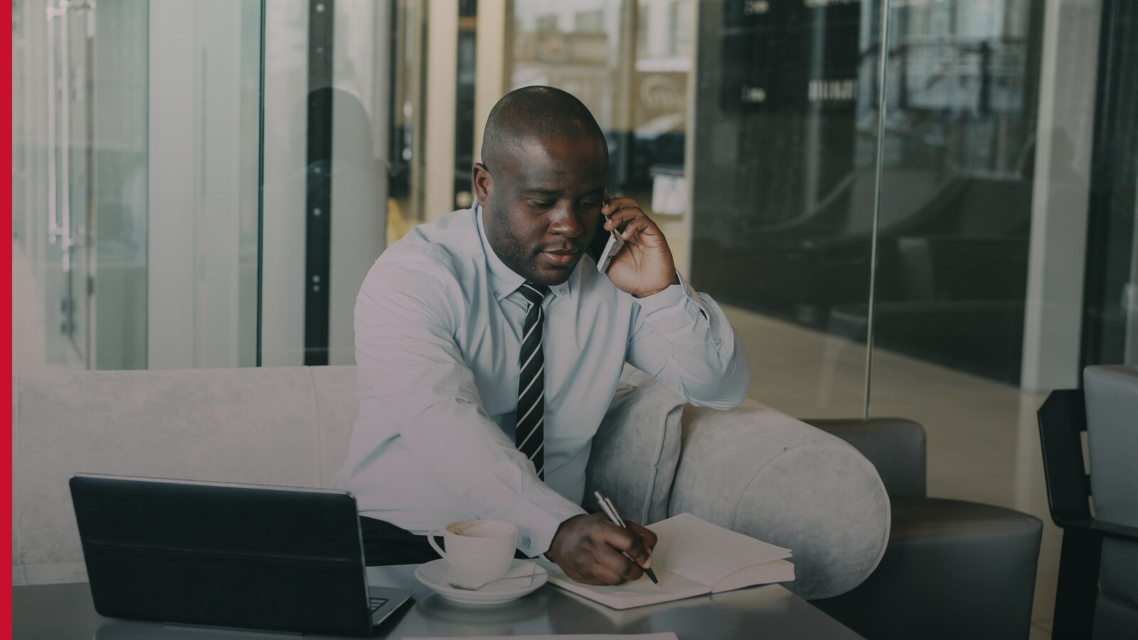 Dirigeant d’entreprise au téléphone prenant des notes pour encadrer sa prospection commerciale